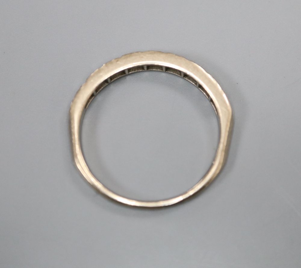 An 18ct white gold and nine stone diamond chip set half hoop eternity ring, size O, gross 2.6 grams.